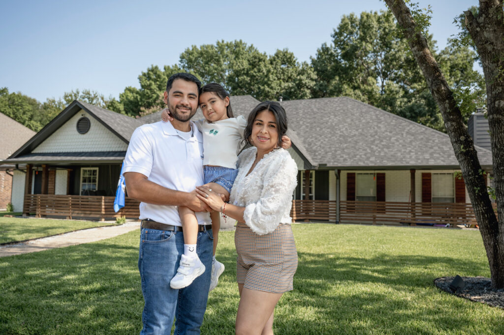 A family portrait of the owners of Shepherd Commercial Roofing, standing in front of a home, symbolizing their dedication to quality and community.