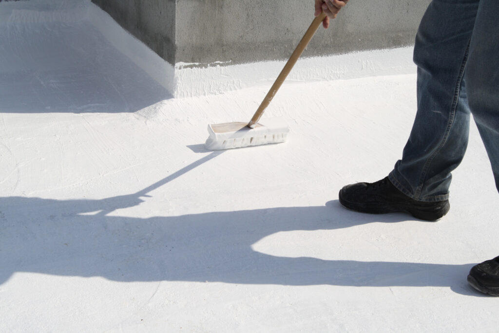 Application of a reflective roof coating during a commercial roof restoration by Shepherd Commercial Roofing, enhancing durability and energy efficiency.