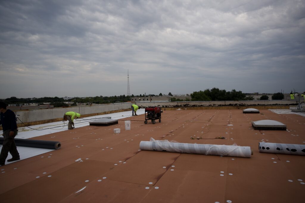 Shepherd commercial roofing workers installing roofing system on roof